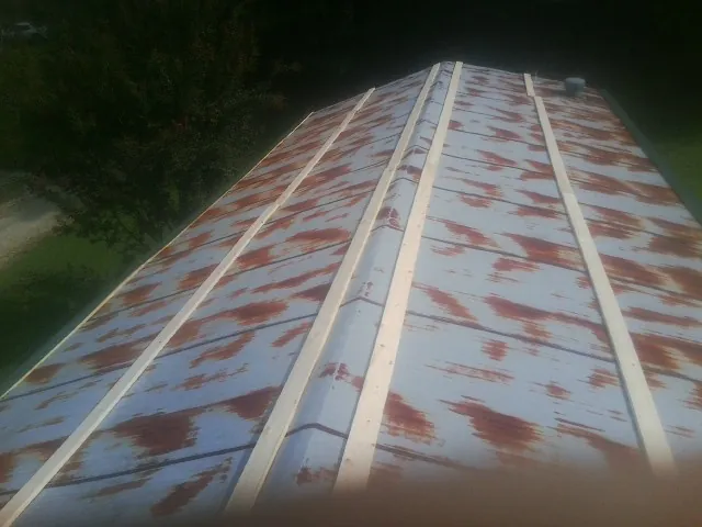 Rusted metal roof panels with new wood purlins before replacement — Storm Damage Roof Repair in Rindge by Roofing Brothers