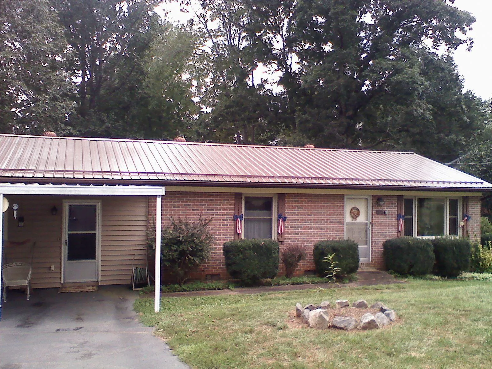 Bronze metal roof and carport on a brick ranch home — Roof Repair work by our crew in Rindge